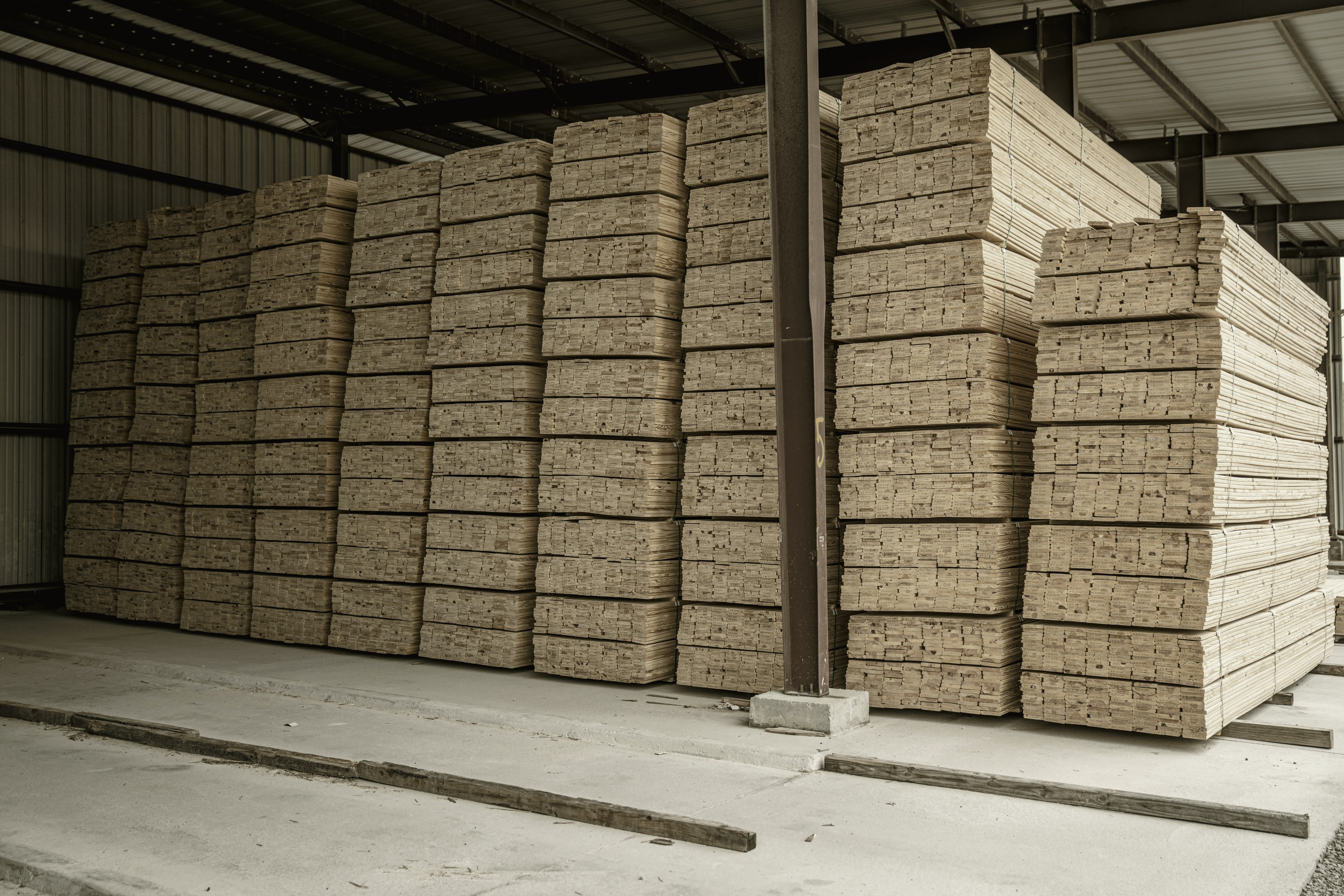 Stacked structural steel and materials in a delivery yard.